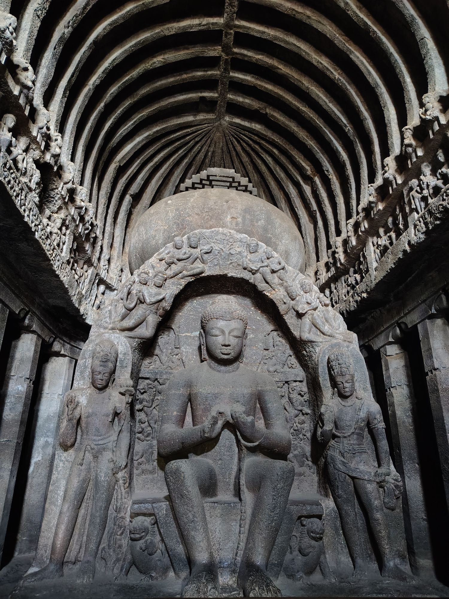 The seated Buddha inside the Buddha temple at Ellora, under a ribbed stone ceiling